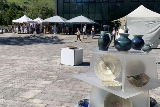 Keramik an einem Verkaufsstand, weitere Stände im Hintergrund