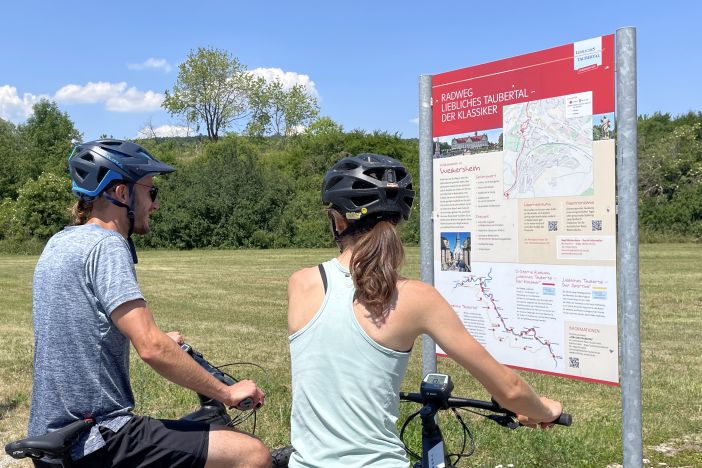 Radfahrer vor Radwegschild vom Lieblichen Taubertal