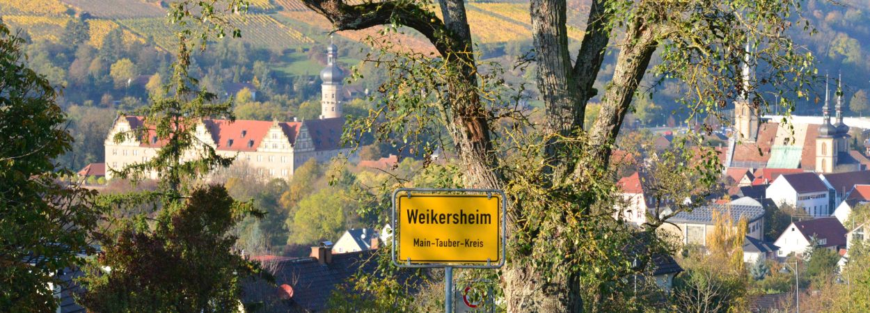 Blick auf Weikersheim mit Ortseingangsschild, Schloss und Kirche